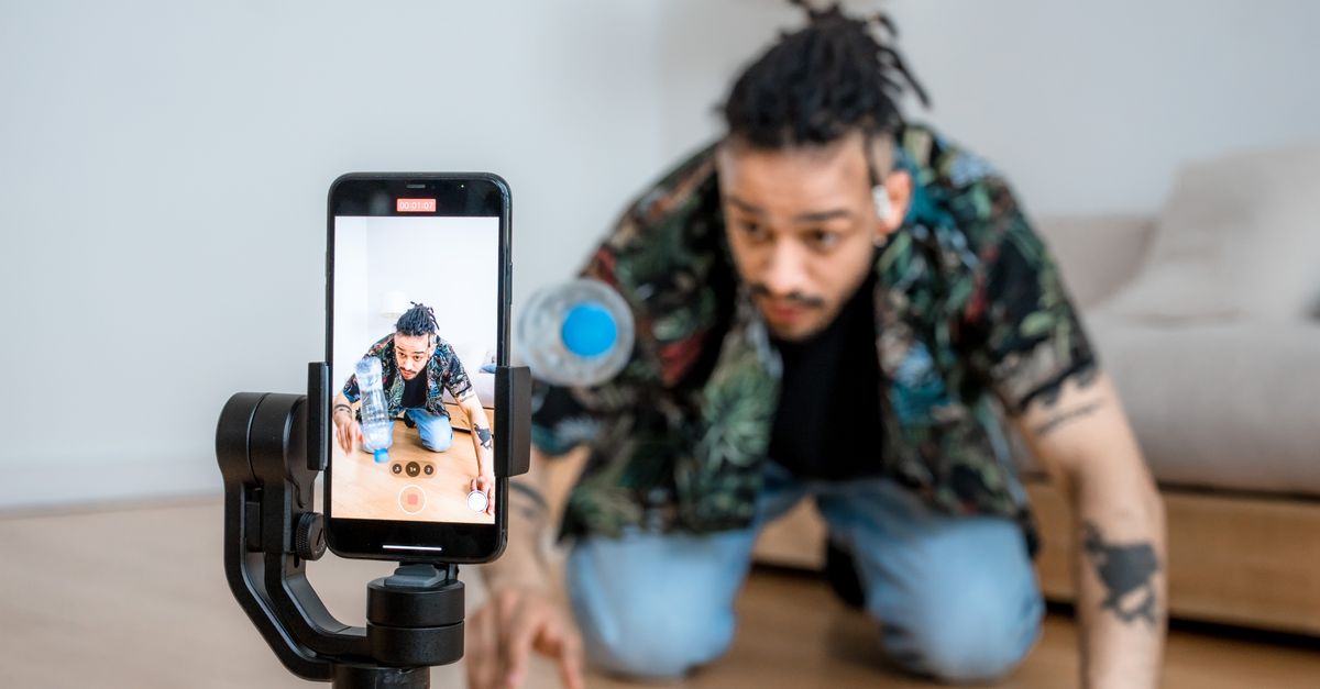 A creator filming short-form video content with a smartphone mounted on a gimbal — the faceless YouTube production setup AI video generators replace
