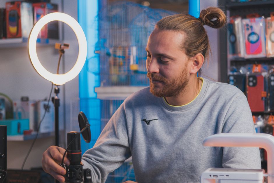 A creator setting up a microphone and ring light in a home studio to start a faceless YouTube channel